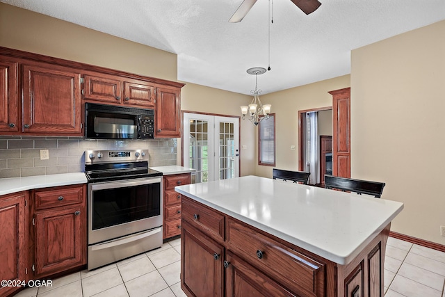 kitchen with hanging light fixtures, ceiling fan with notable chandelier, backsplash, a kitchen island, and electric range