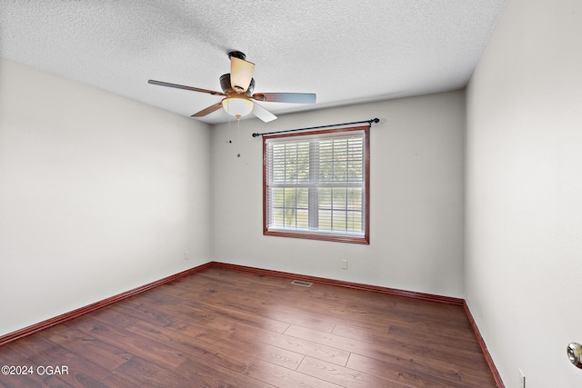 empty room featuring ceiling fan, dark hardwood / wood-style floors, and a textured ceiling