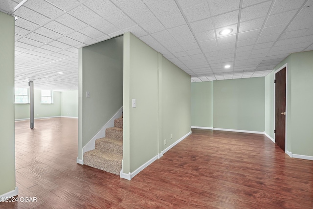 basement with hardwood / wood-style flooring and a paneled ceiling