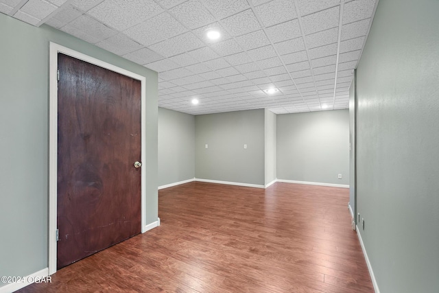 empty room featuring wood-type flooring and a paneled ceiling