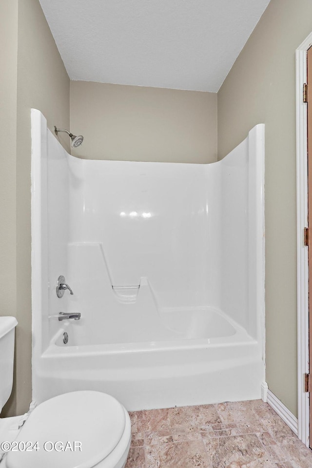 bathroom featuring bathtub / shower combination and toilet