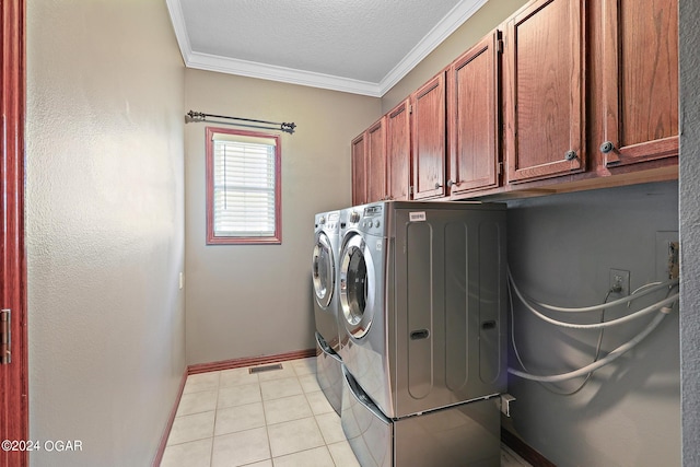 washroom featuring light tile patterned floors, washing machine and clothes dryer, a textured ceiling, cabinets, and crown molding