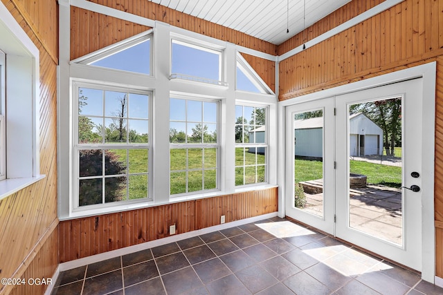 unfurnished sunroom featuring french doors, lofted ceiling, and plenty of natural light