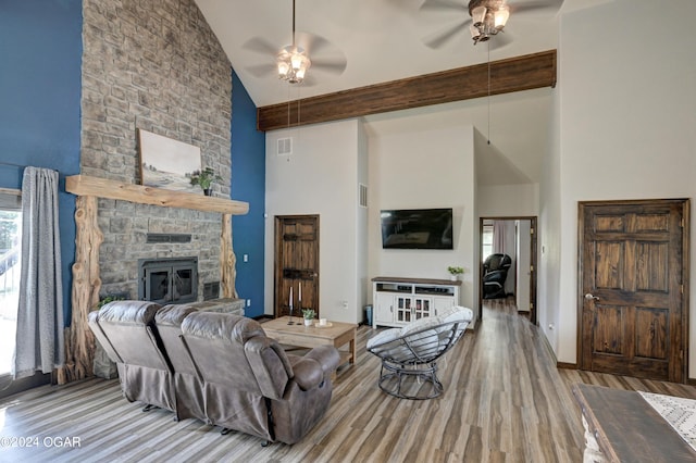 living room with ceiling fan, beam ceiling, light hardwood / wood-style flooring, high vaulted ceiling, and a fireplace