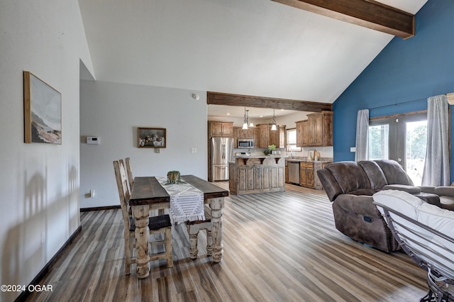 dining area with an inviting chandelier, beam ceiling, dark hardwood / wood-style floors, and high vaulted ceiling