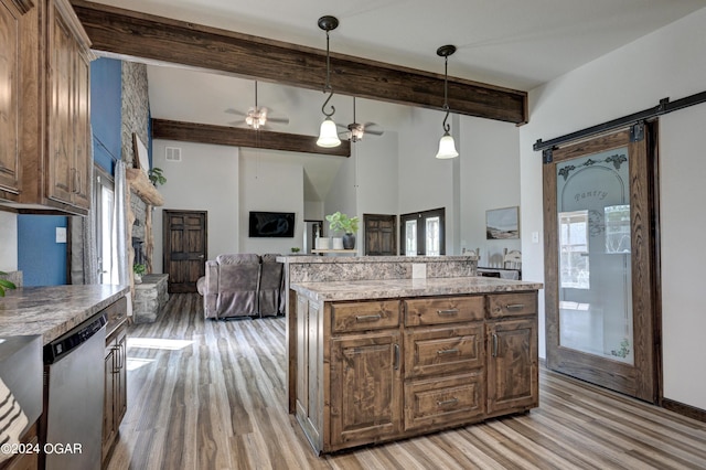 kitchen featuring a healthy amount of sunlight, ceiling fan, decorative light fixtures, and a barn door