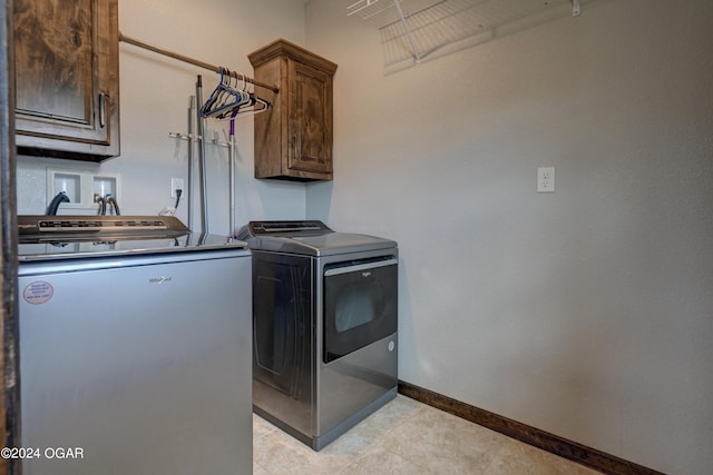 clothes washing area featuring washer and dryer and cabinets