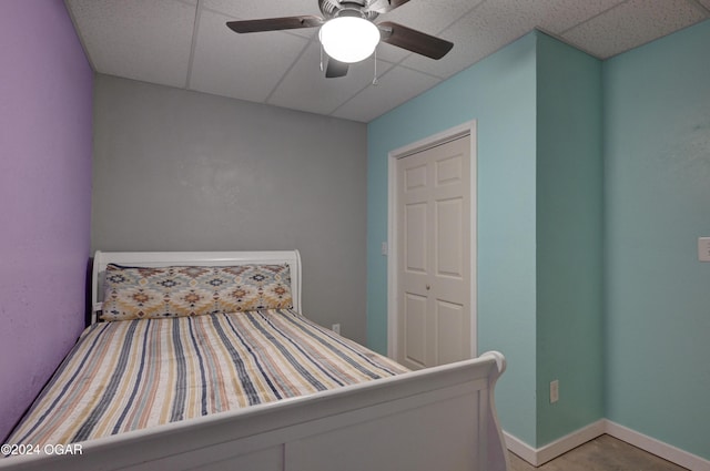 unfurnished bedroom with a paneled ceiling, ceiling fan, and a closet