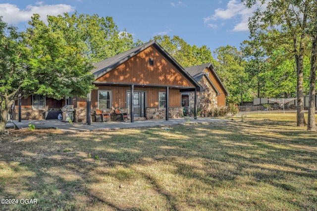 back of house featuring a lawn and a patio area