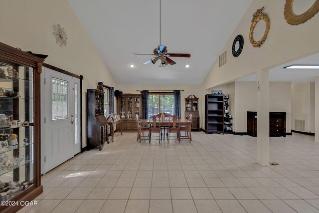 dining room with ceiling fan, light tile patterned floors, and high vaulted ceiling