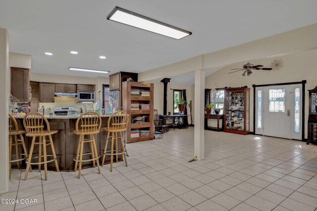 unfurnished dining area featuring ceiling fan and light tile patterned floors