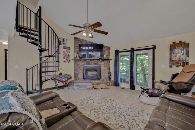 living room featuring light tile patterned floors, a fireplace, ceiling fan, and high vaulted ceiling