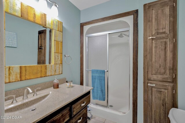 bathroom featuring vanity, a shower with shower door, toilet, and tile patterned floors