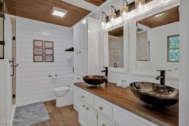 bathroom featuring wood ceiling, wooden walls, hardwood / wood-style floors, and vanity