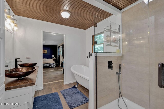 bathroom with plus walk in shower, hardwood / wood-style flooring, ornamental molding, wooden ceiling, and vanity