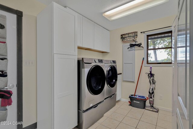 clothes washing area with separate washer and dryer, cabinets, and light tile patterned floors