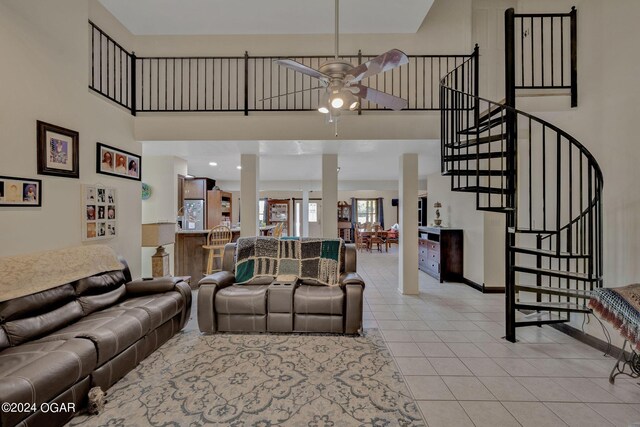 living room featuring light tile patterned floors, a high ceiling, and ceiling fan