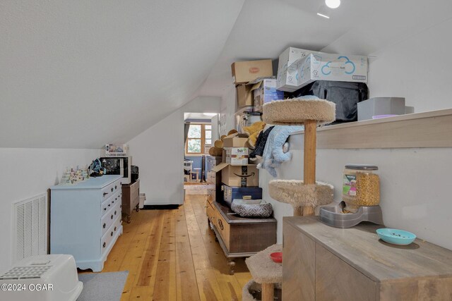 bedroom with light hardwood / wood-style flooring and vaulted ceiling