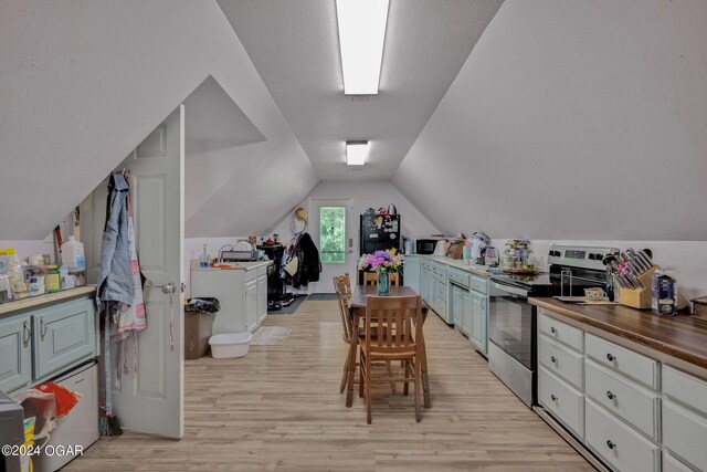 interior space featuring a textured ceiling, lofted ceiling, light hardwood / wood-style floors, and sink