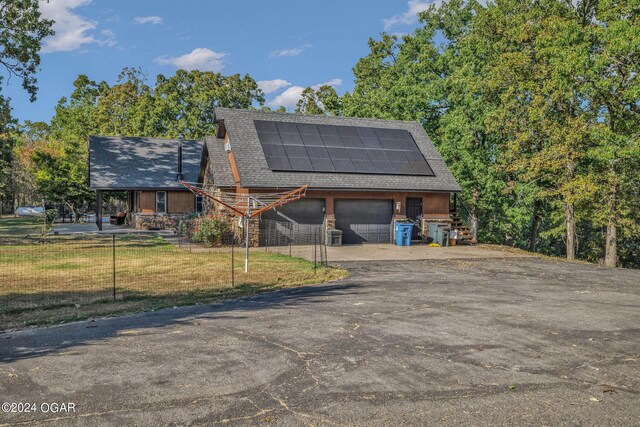 exterior space featuring a garage, solar panels, and a front yard