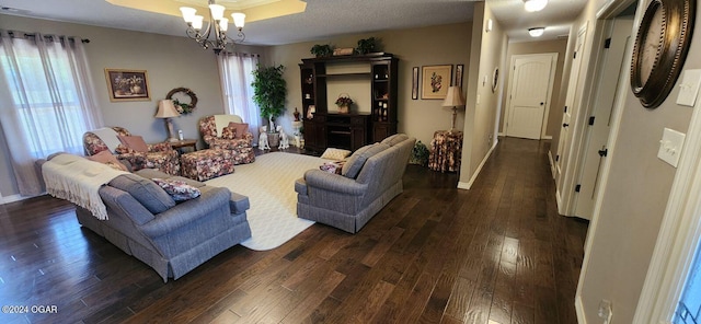 living room featuring a textured ceiling, dark hardwood / wood-style flooring, a chandelier, and a wealth of natural light