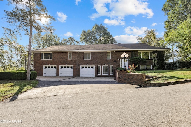 raised ranch featuring a front yard and a garage