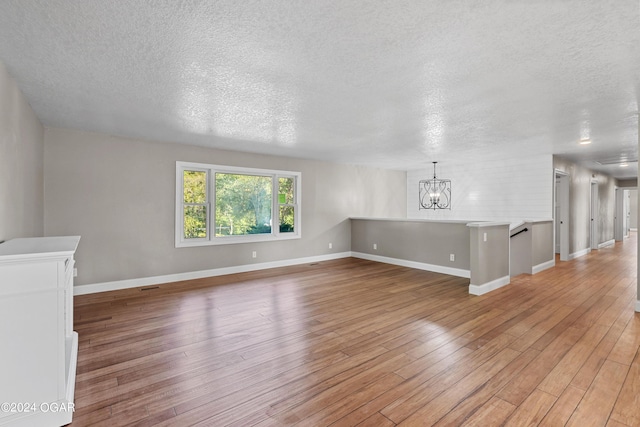 interior space with a chandelier, light hardwood / wood-style floors, and a textured ceiling