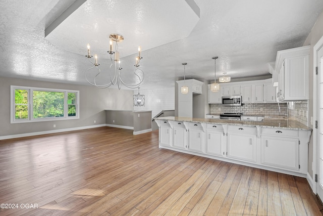 kitchen featuring white cabinets, a textured ceiling, appliances with stainless steel finishes, and light hardwood / wood-style flooring