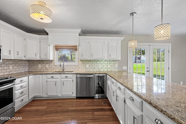 kitchen featuring pendant lighting, sink, white cabinetry, appliances with stainless steel finishes, and dark hardwood / wood-style flooring