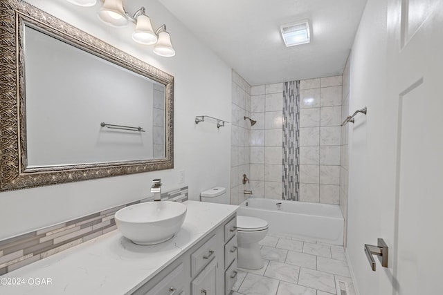 full bathroom featuring tiled shower / bath combo, vanity, and toilet