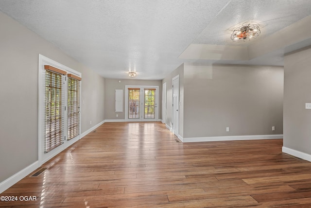 empty room featuring a textured ceiling and light hardwood / wood-style floors