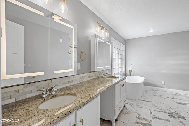 bathroom with a tub to relax in, a textured ceiling, vanity, and backsplash