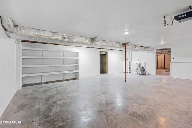 garage with water heater and a garage door opener