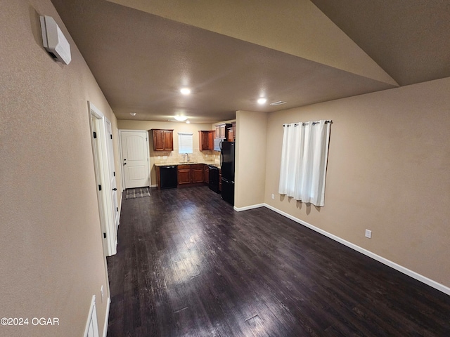 unfurnished living room featuring dark wood-type flooring and sink