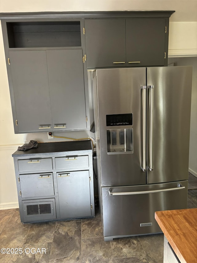 kitchen featuring gray cabinetry, high end fridge, and butcher block countertops