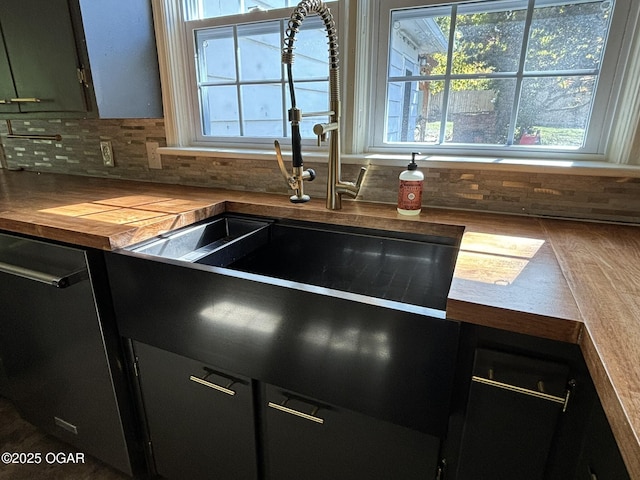 kitchen featuring dishwasher, sink, backsplash, and wooden counters