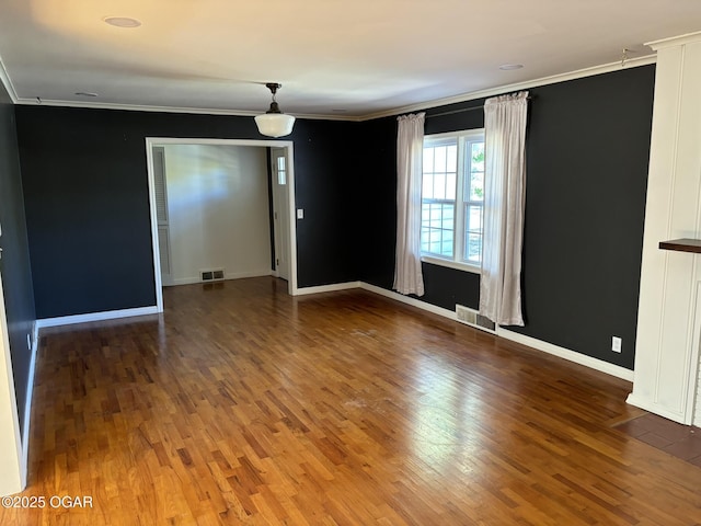 spare room featuring wood-type flooring and ornamental molding