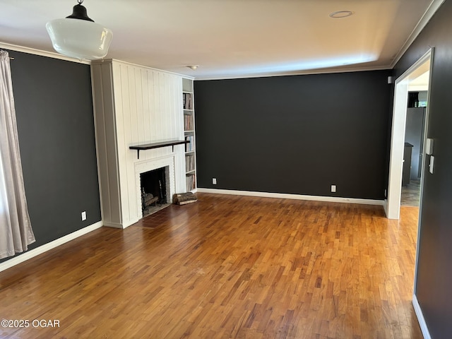 unfurnished living room featuring a fireplace, hardwood / wood-style flooring, and ornamental molding