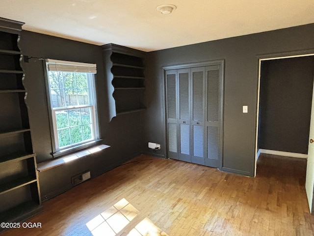 unfurnished bedroom featuring light wood-type flooring and a closet