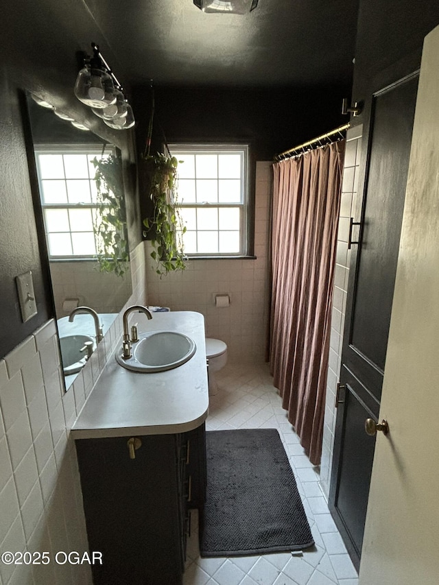 bathroom with a shower with curtain, tile patterned flooring, toilet, vanity, and tile walls