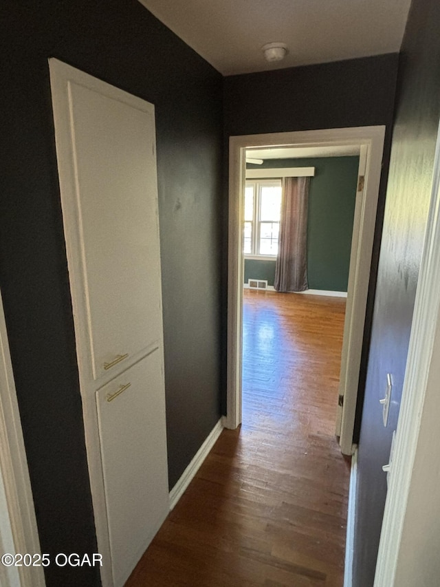 corridor with hardwood / wood-style floors