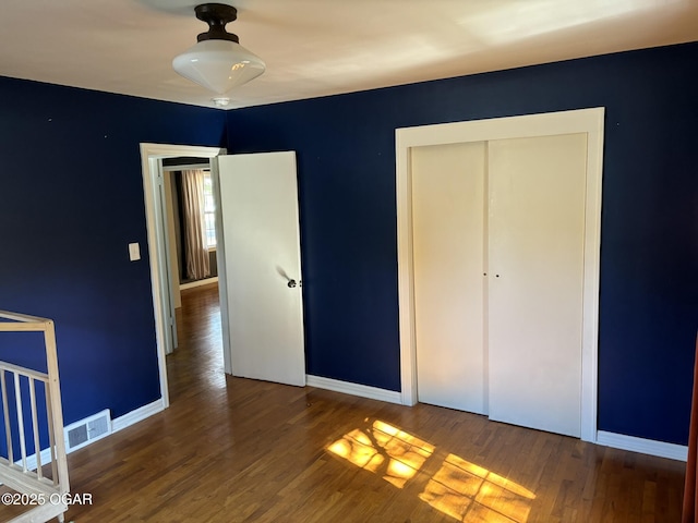 unfurnished bedroom with hardwood / wood-style flooring and a closet