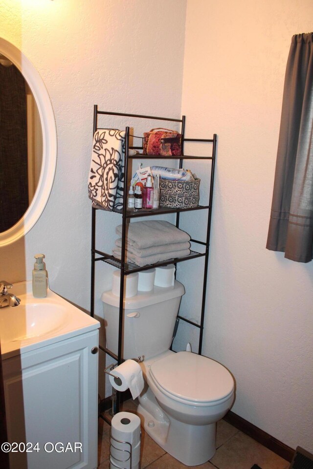 bathroom featuring tile patterned floors, vanity, and toilet