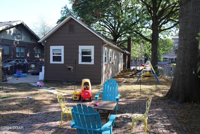 rear view of property with a playground