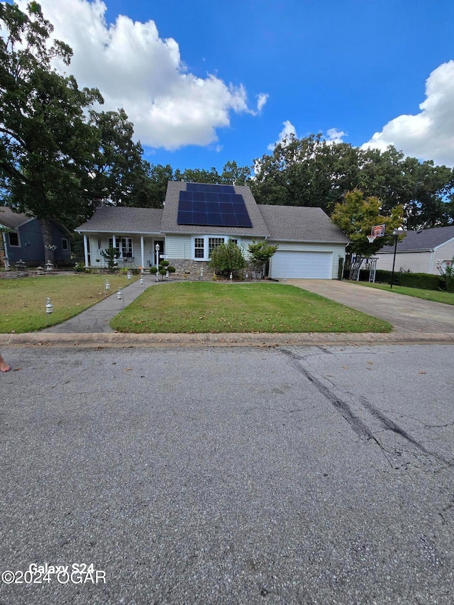 view of front facade with a garage, solar panels, and a front yard