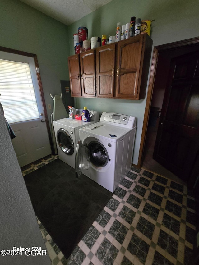 washroom featuring separate washer and dryer, cabinets, and a textured ceiling