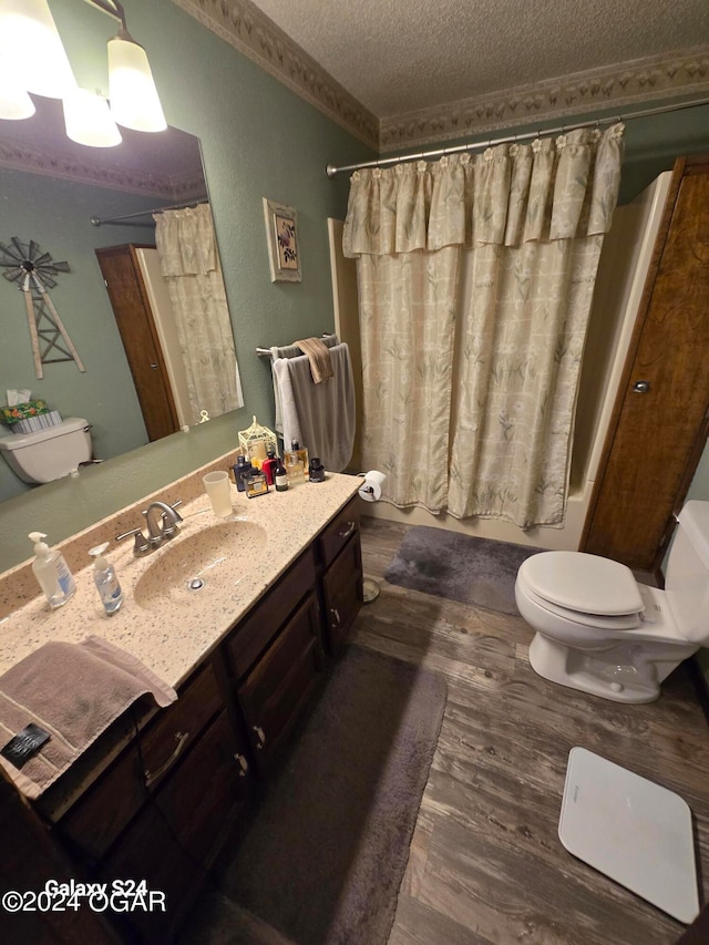 full bathroom with shower / bathtub combination with curtain, vanity, a textured ceiling, toilet, and hardwood / wood-style floors