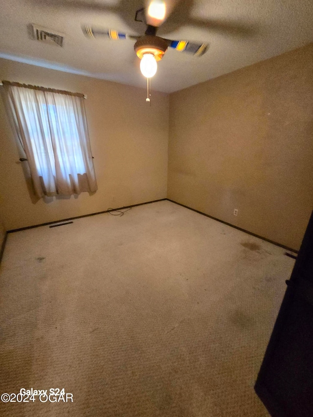 spare room featuring carpet and ceiling fan