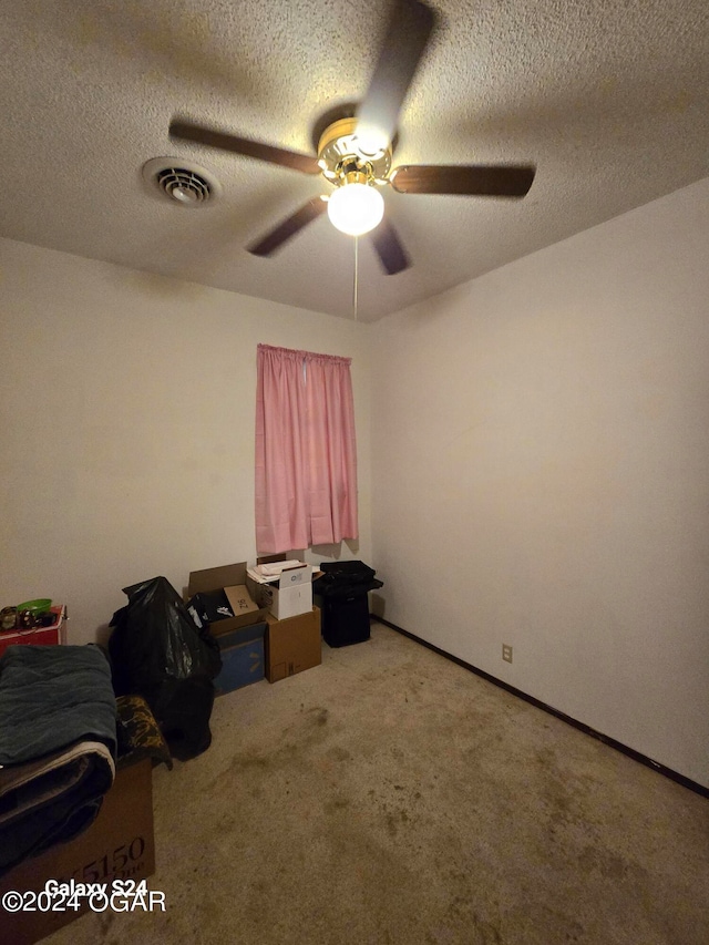 unfurnished bedroom featuring ceiling fan, carpet floors, and a textured ceiling