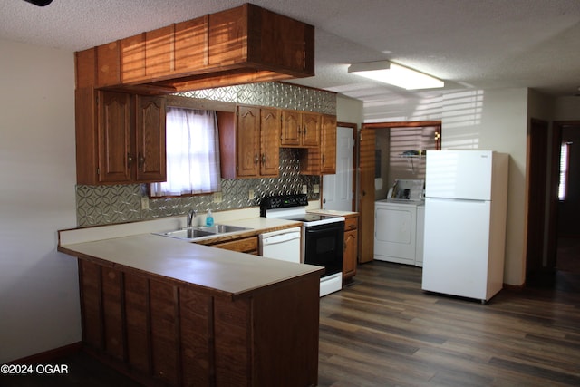 kitchen with kitchen peninsula, white appliances, sink, a textured ceiling, and dark hardwood / wood-style floors